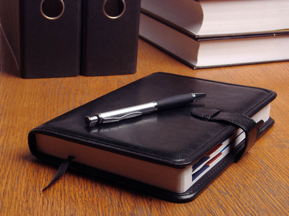 Organizer Black organizer on the office desk surrounded by documents and files;